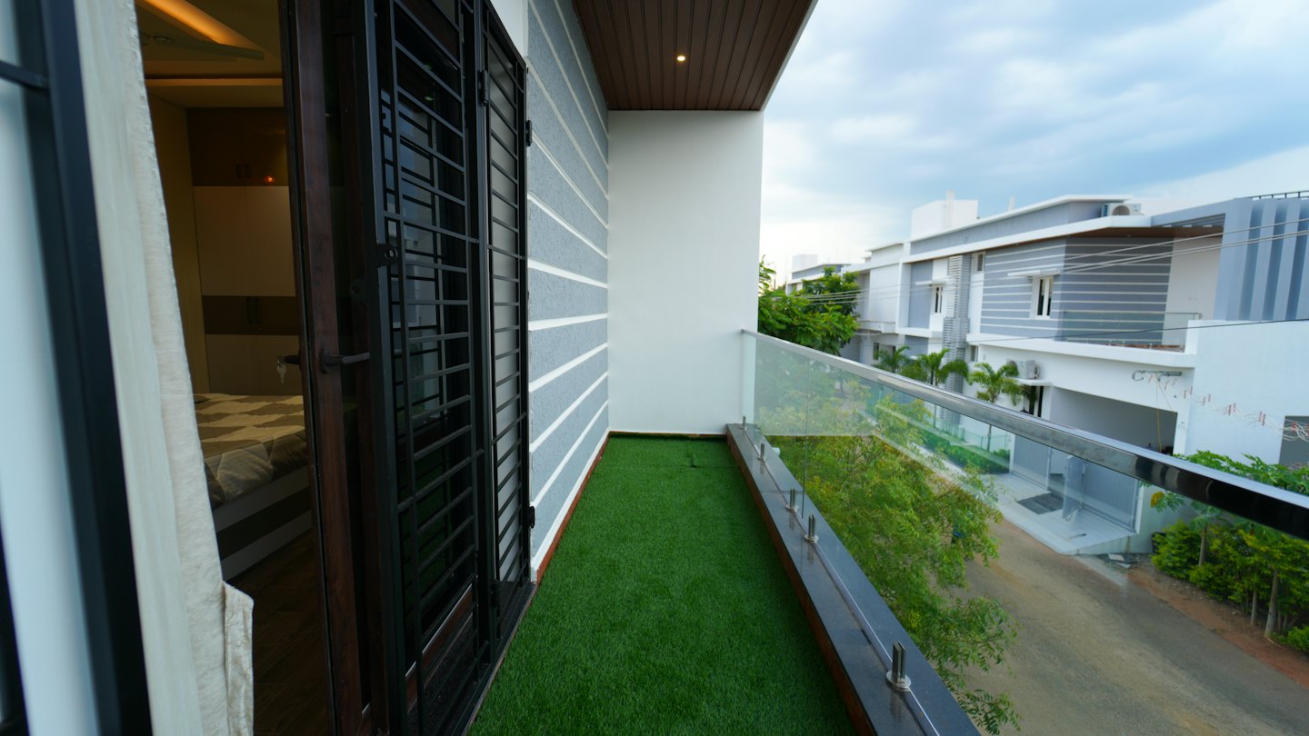 Balcony overlooking a street with modern homes under a gray sky.