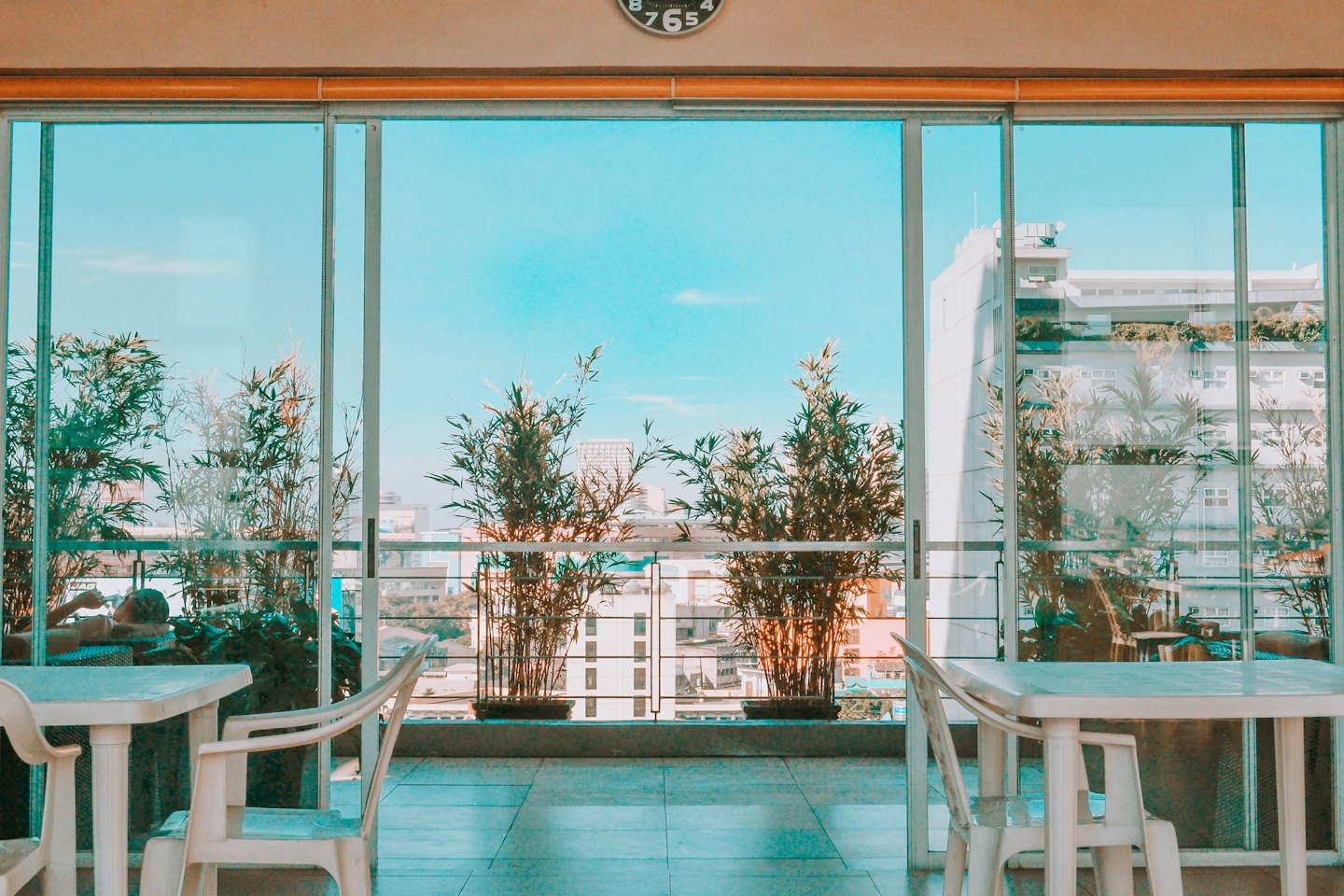 Urban balcony with seating overlooking a city skyline.